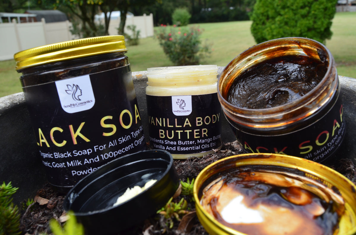 Black soap and vanilla body butter jars with visible branding on a natural background.