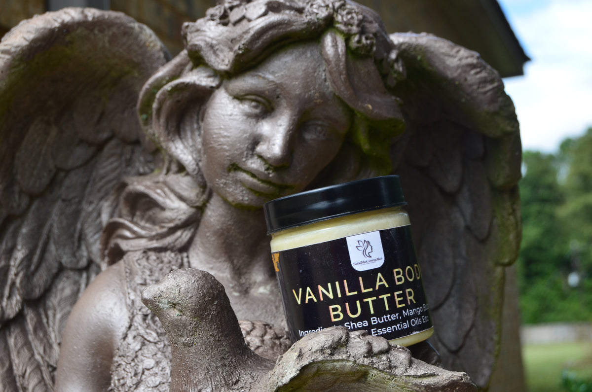 Send Me Cosmetics Vanilla Body Butter on a stone angel statue with a blurred natural background